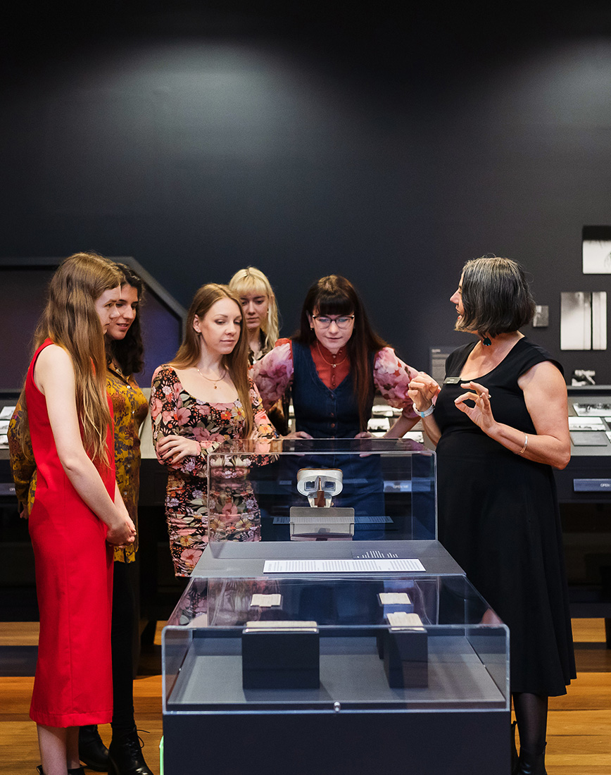 Group of people on a tour in a dark and moody exhibition room