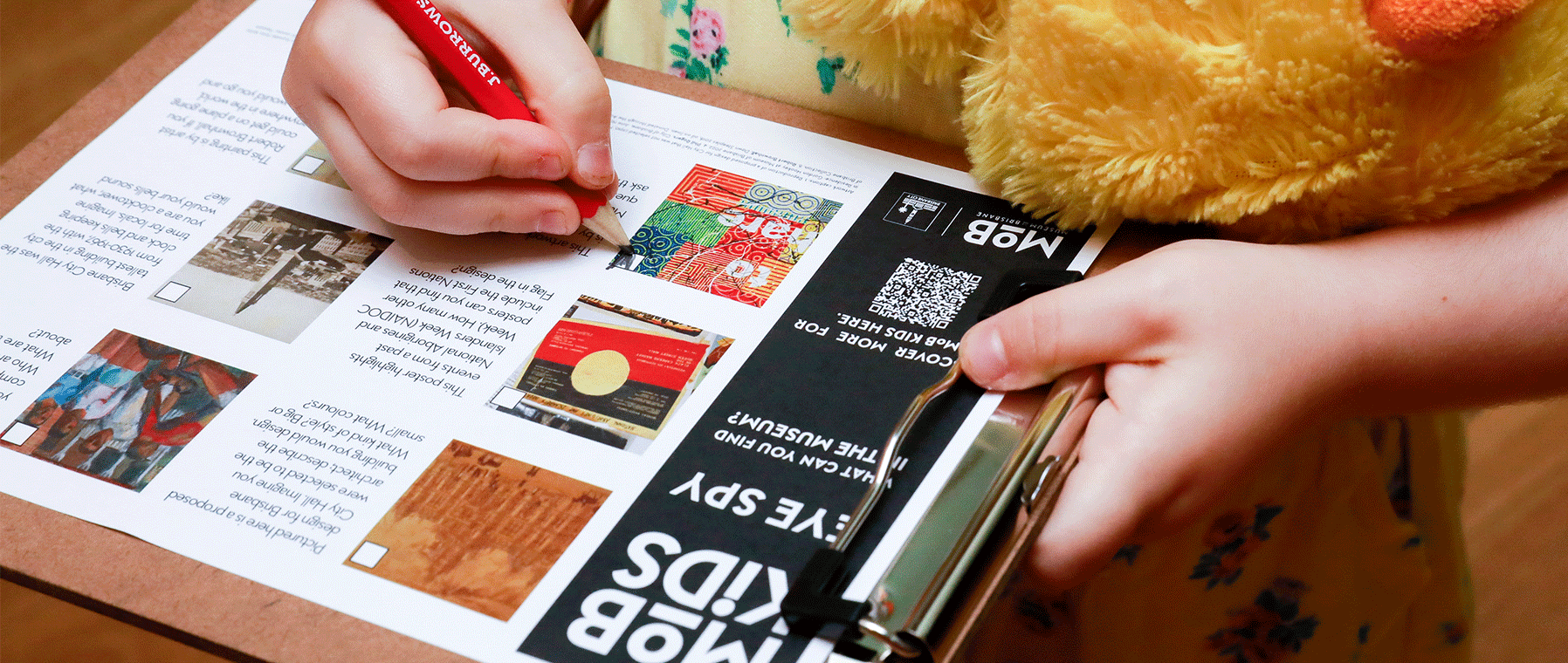 A pair of hands holding a printed eye spy activity.