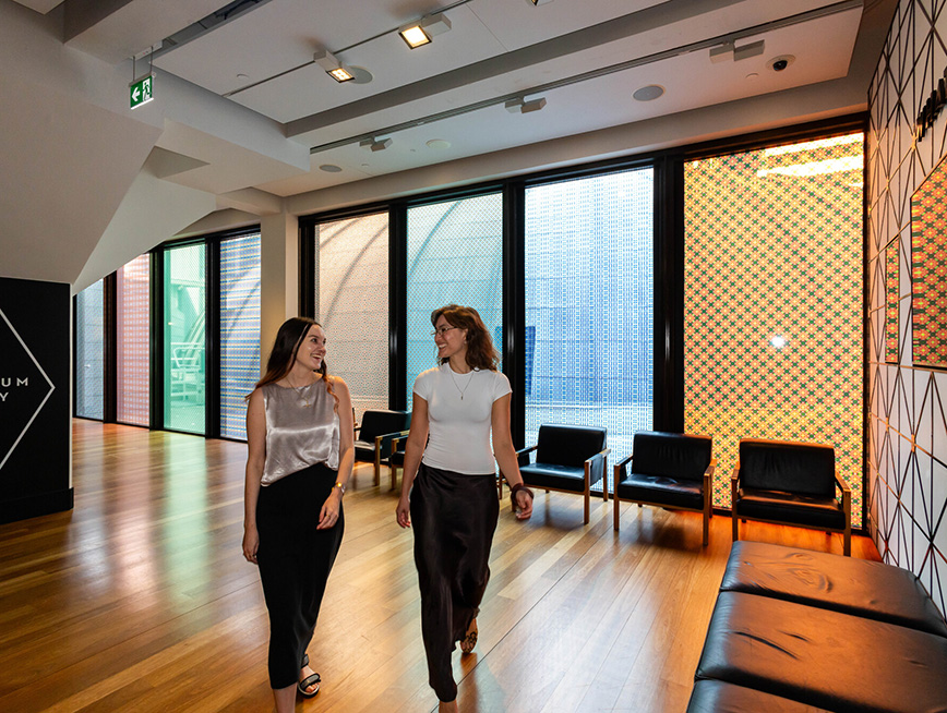 Two women walking in the museum foyer smiling