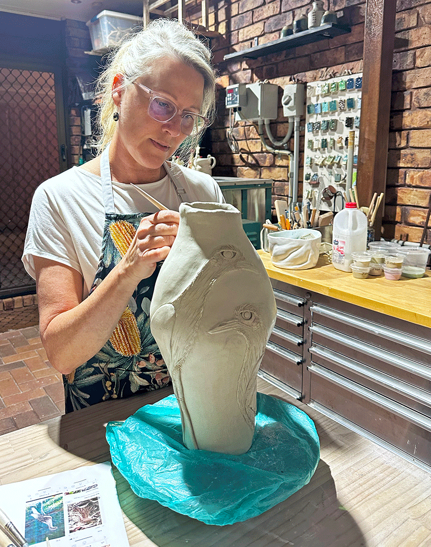 Artist Marlyn Radley shaping a ceramic work in her studio.