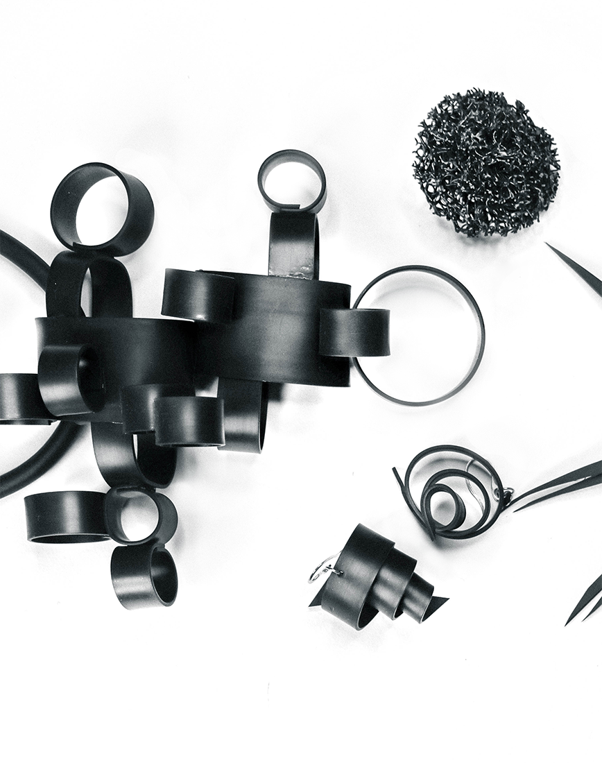Black and white flat lay image of MIKAs rubber jewellery, shaped as spikes, coral like spheres, cylinders and spirals.