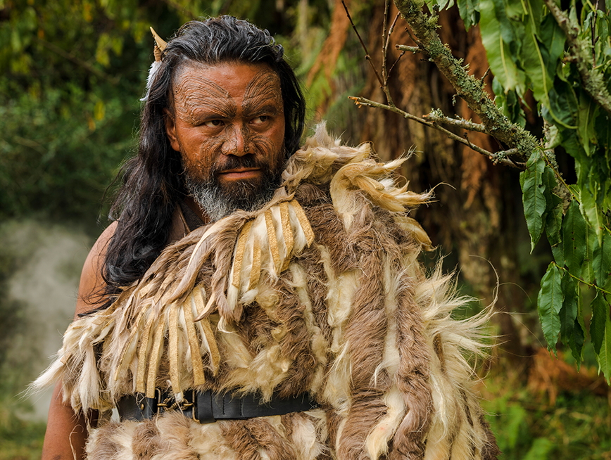 KA WHAWHAI TONU movie still captures a New Zealander tribal man surrounded by green forest