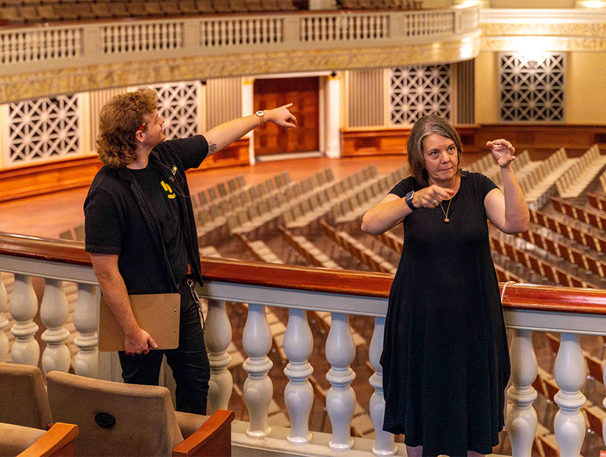 Two tour guides, one is pointing and another interpreting in Auslan