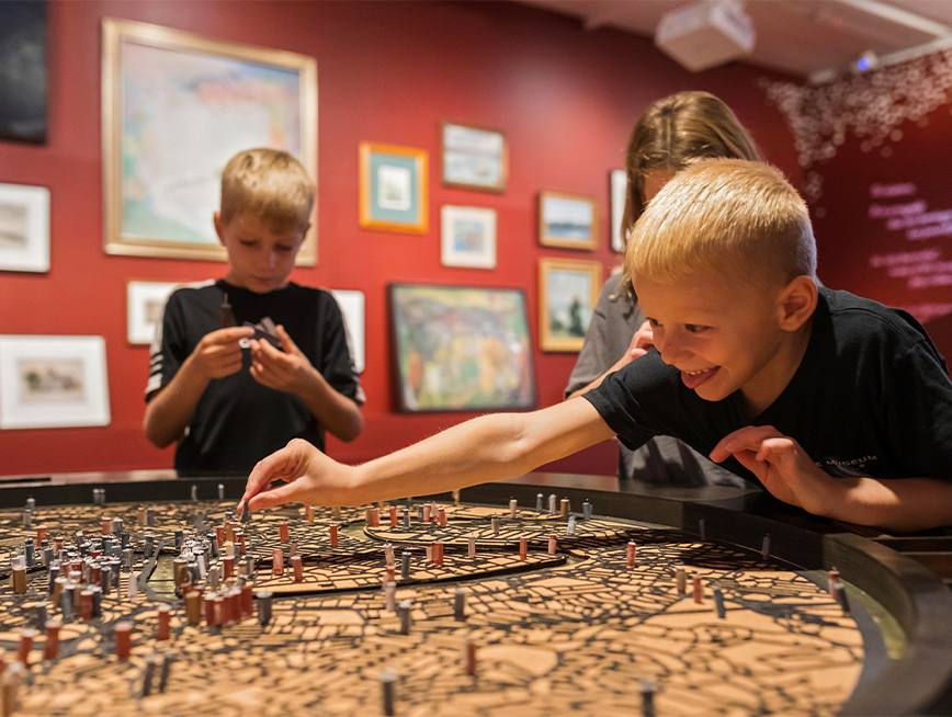 Two children interacting with Dead Puppet Society's work as part of Making Place: 100 Views of Brisbane.