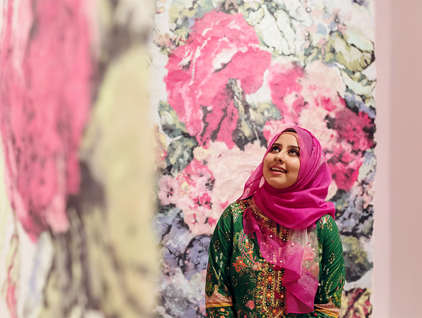 Visitor looking at Karen Stone's artwork at Rearranged- Art of the Flower exhibition.
