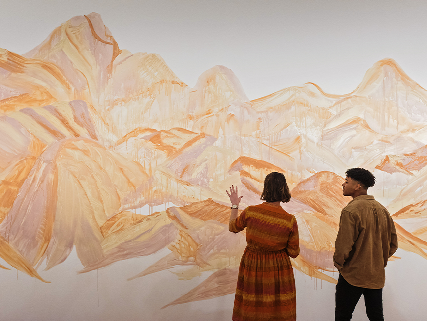 Two people looking at Jody Rallah's mural.