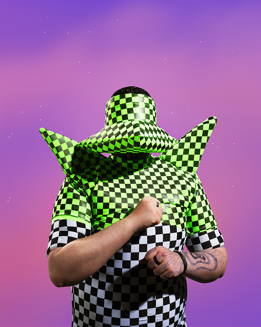 A person in a green and black checker suit, hands in fists.