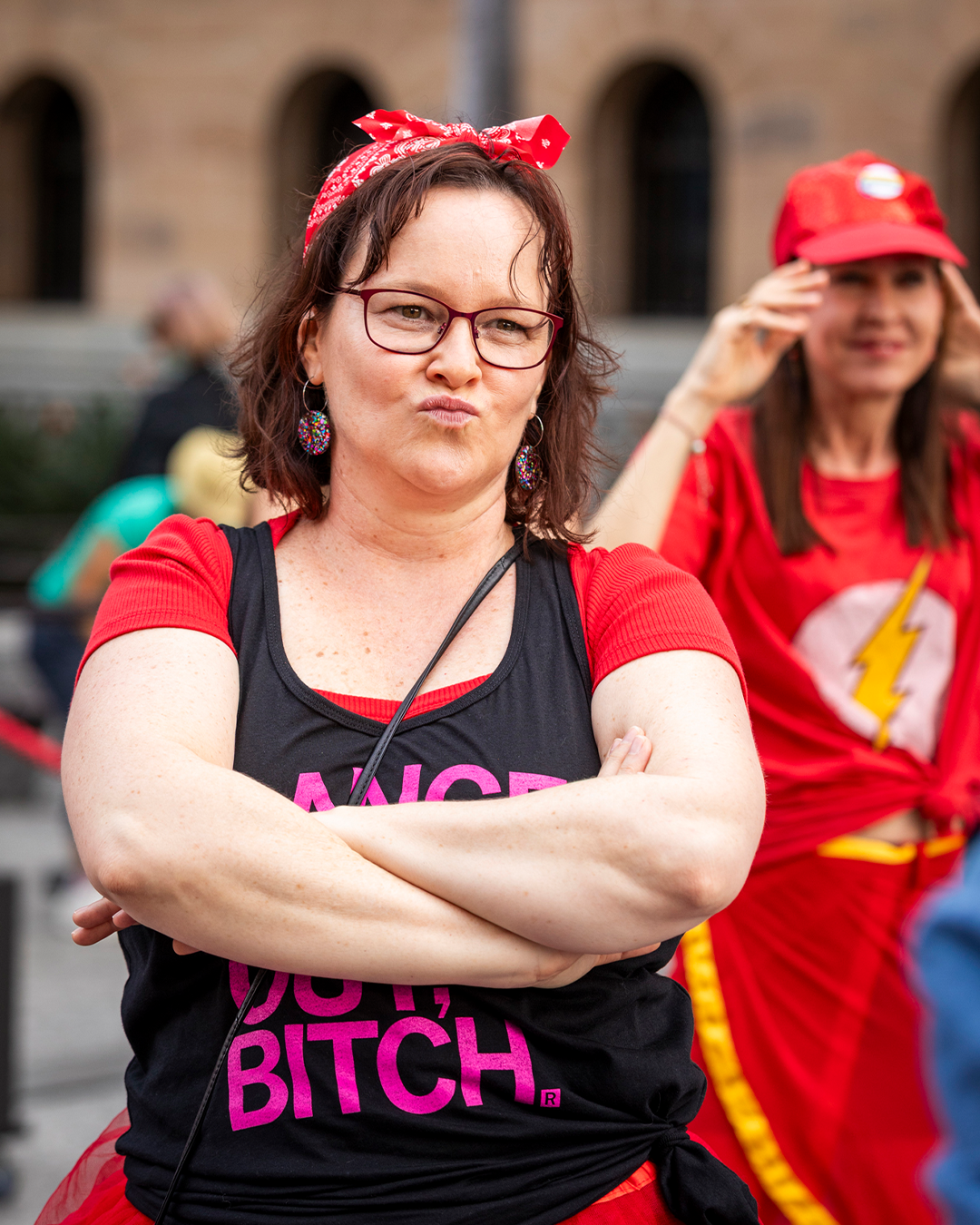 A woman posing with their hands crossed.