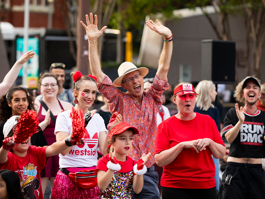 A group of people wearing red clothes, dancing.
