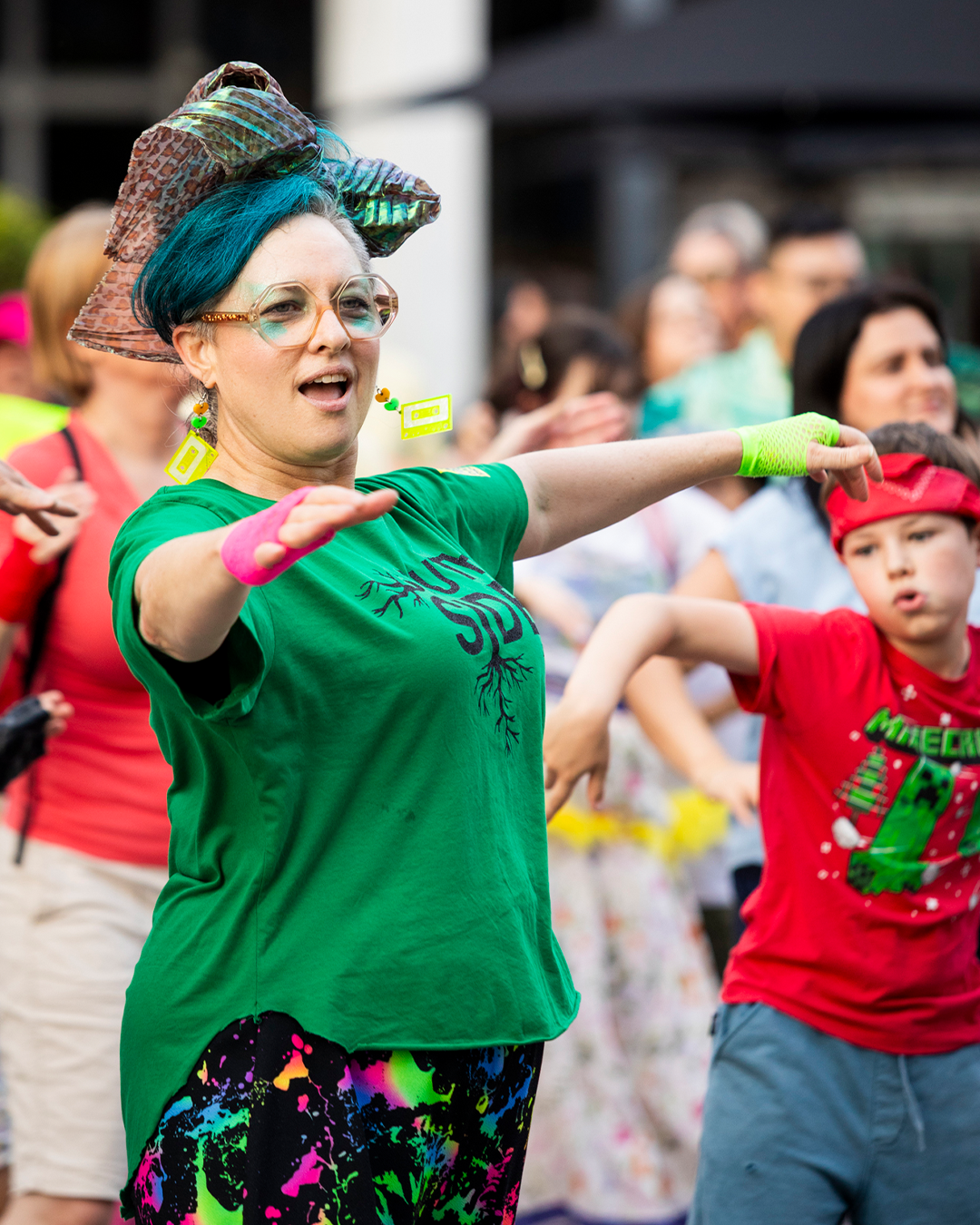 A woman in green with hands up.