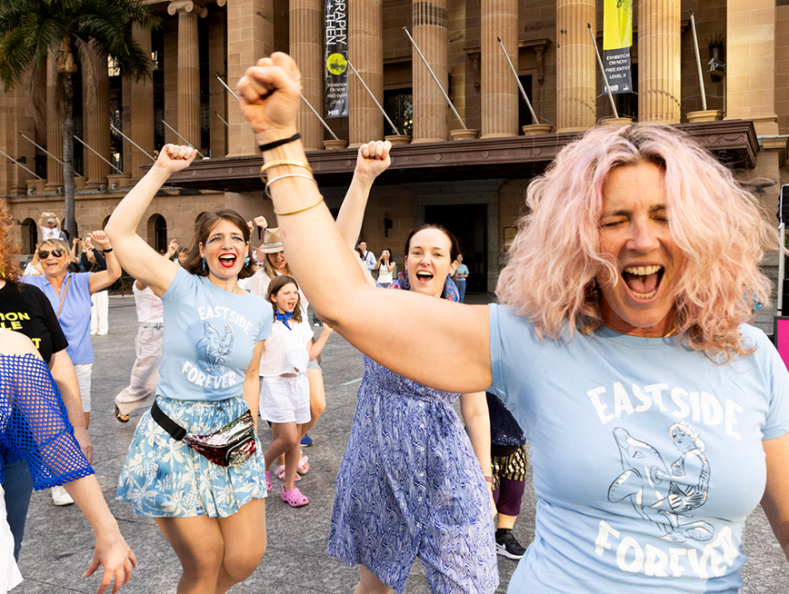 A group of people wearing blue clothes, dancing.