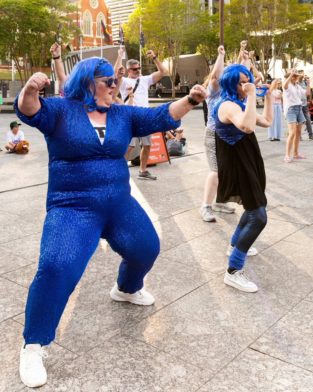 A group of people wearing blue, dancing.