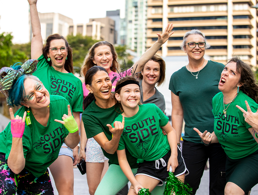 A group of people wearing green clothes, smiling at the camera.