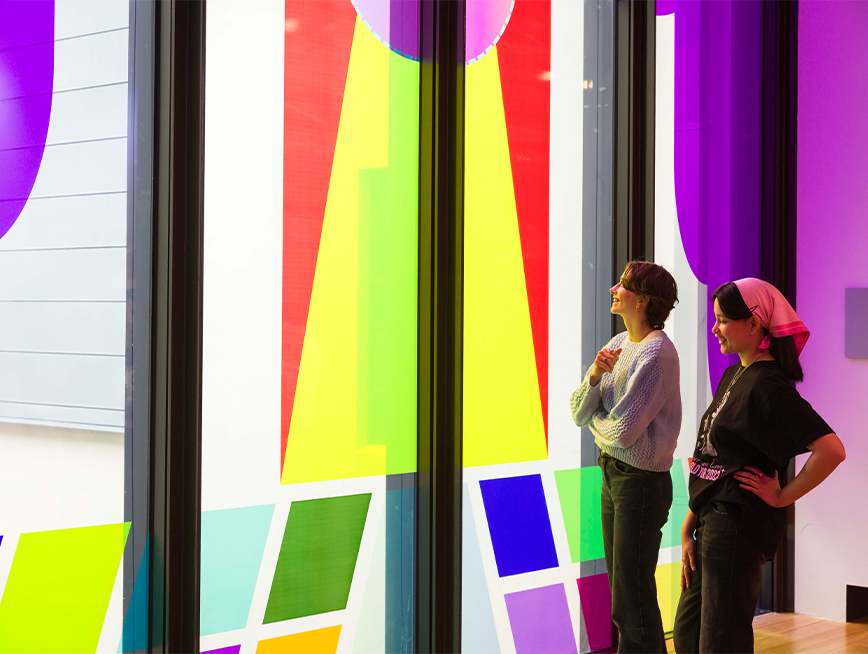 Visitors looking at the colourful window vinyl.