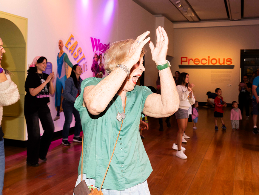 A woman holding her hand high clapping.