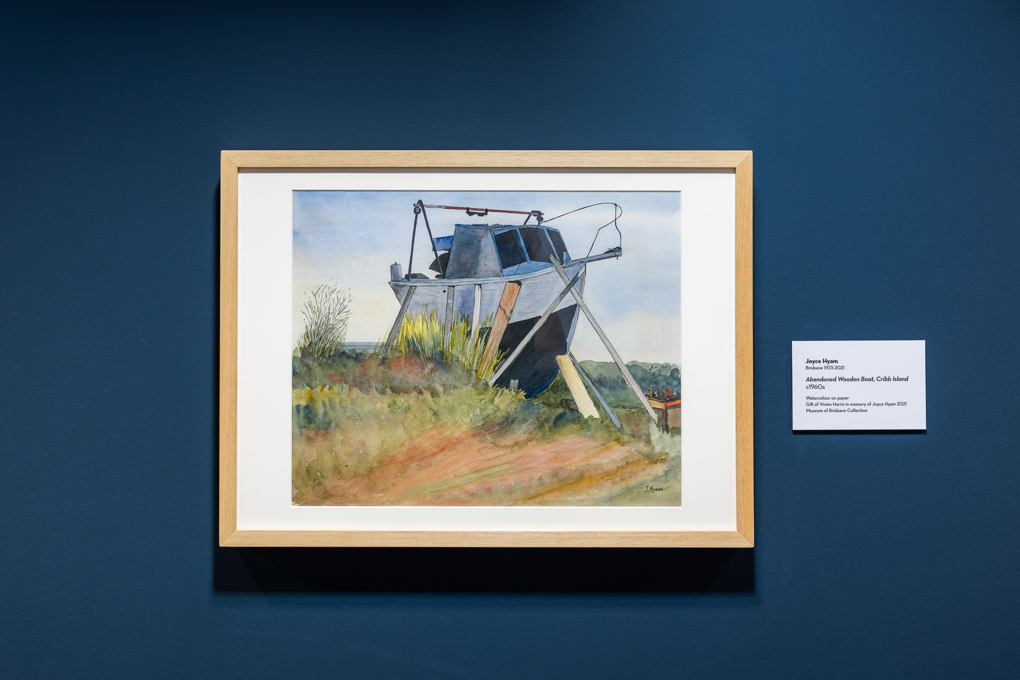 Watercolour painting of an old boat on shore.