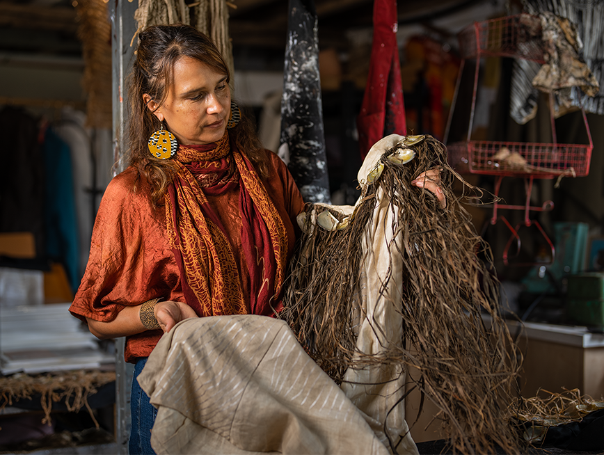 Delvene Cockatoo-Collins holding textiles in her studio.