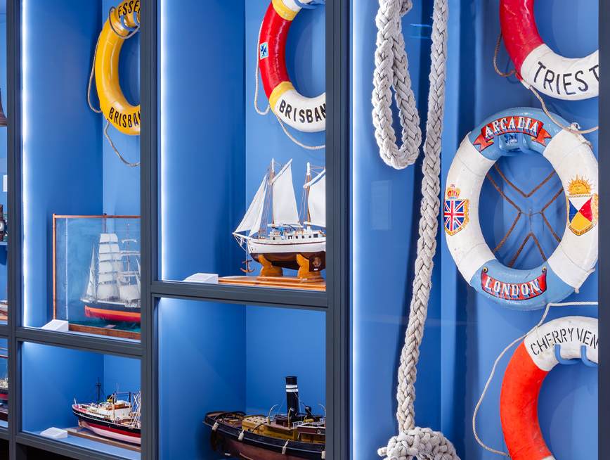 A display of boat models, boat lifebuoy and rope.