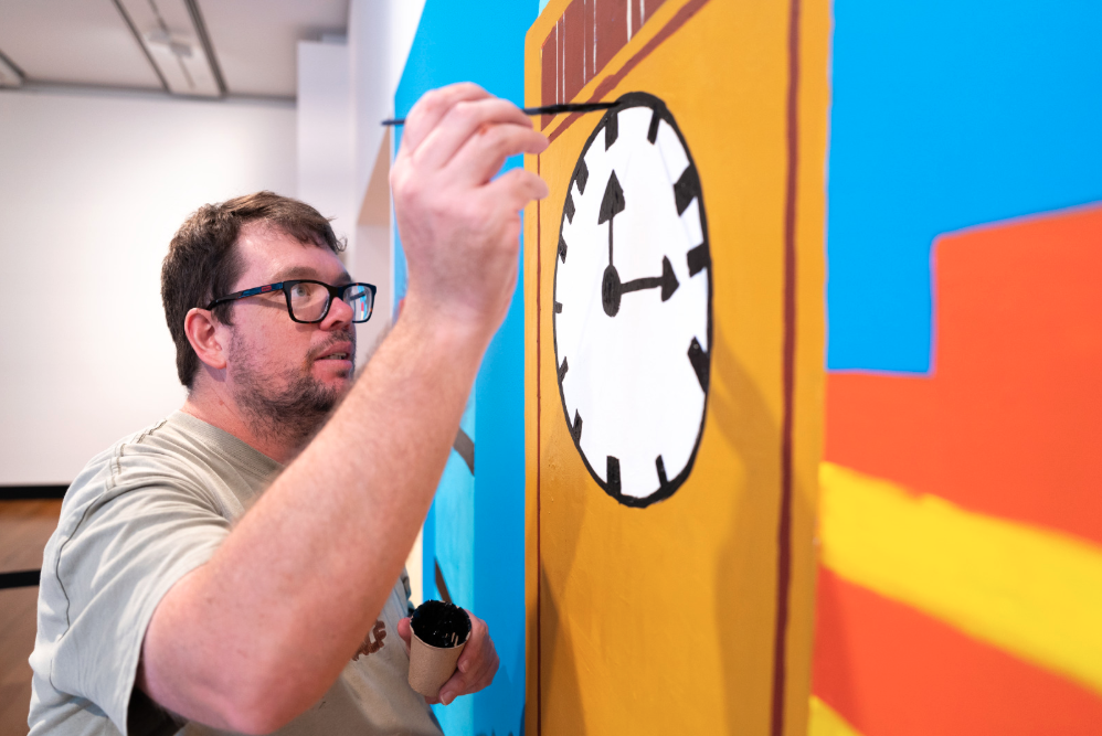 Artist painting a clock on the wall