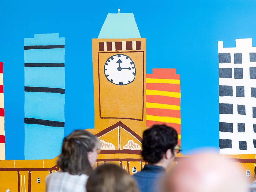 Audience facing the clock tower mural by Martin Edge.