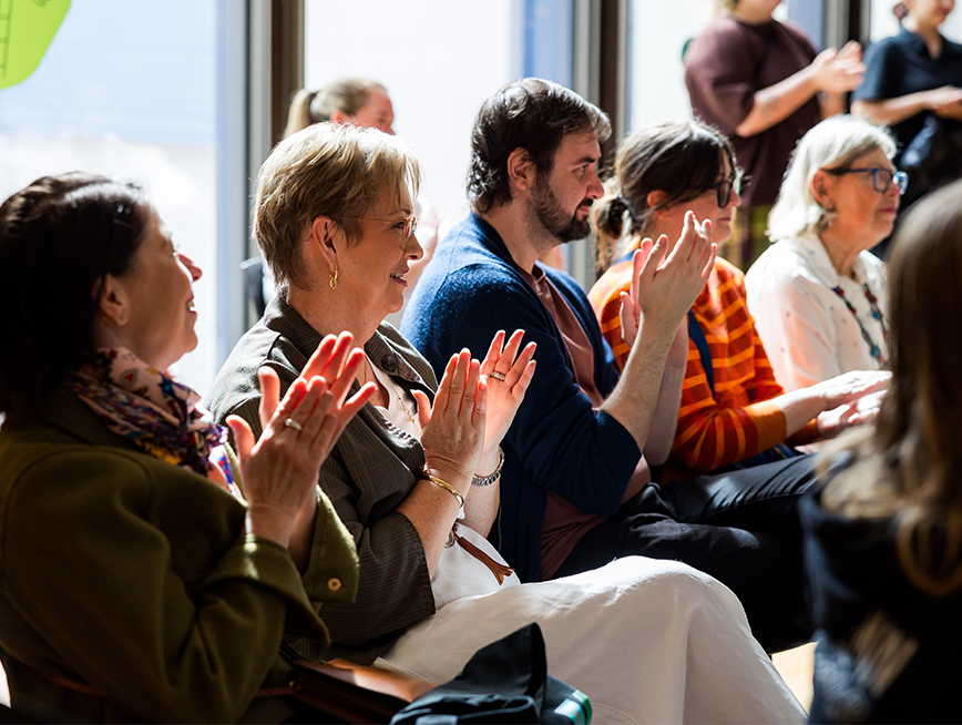 Audience clapping their hands together at the artist talk.