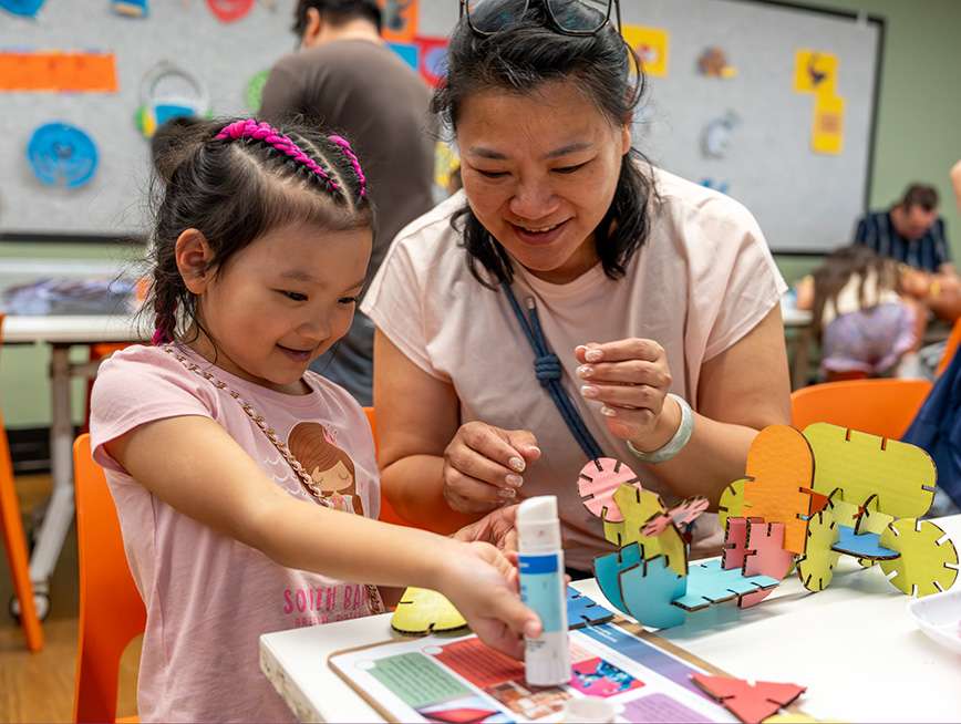 Child and mother smiling and creating sculptures in the museum