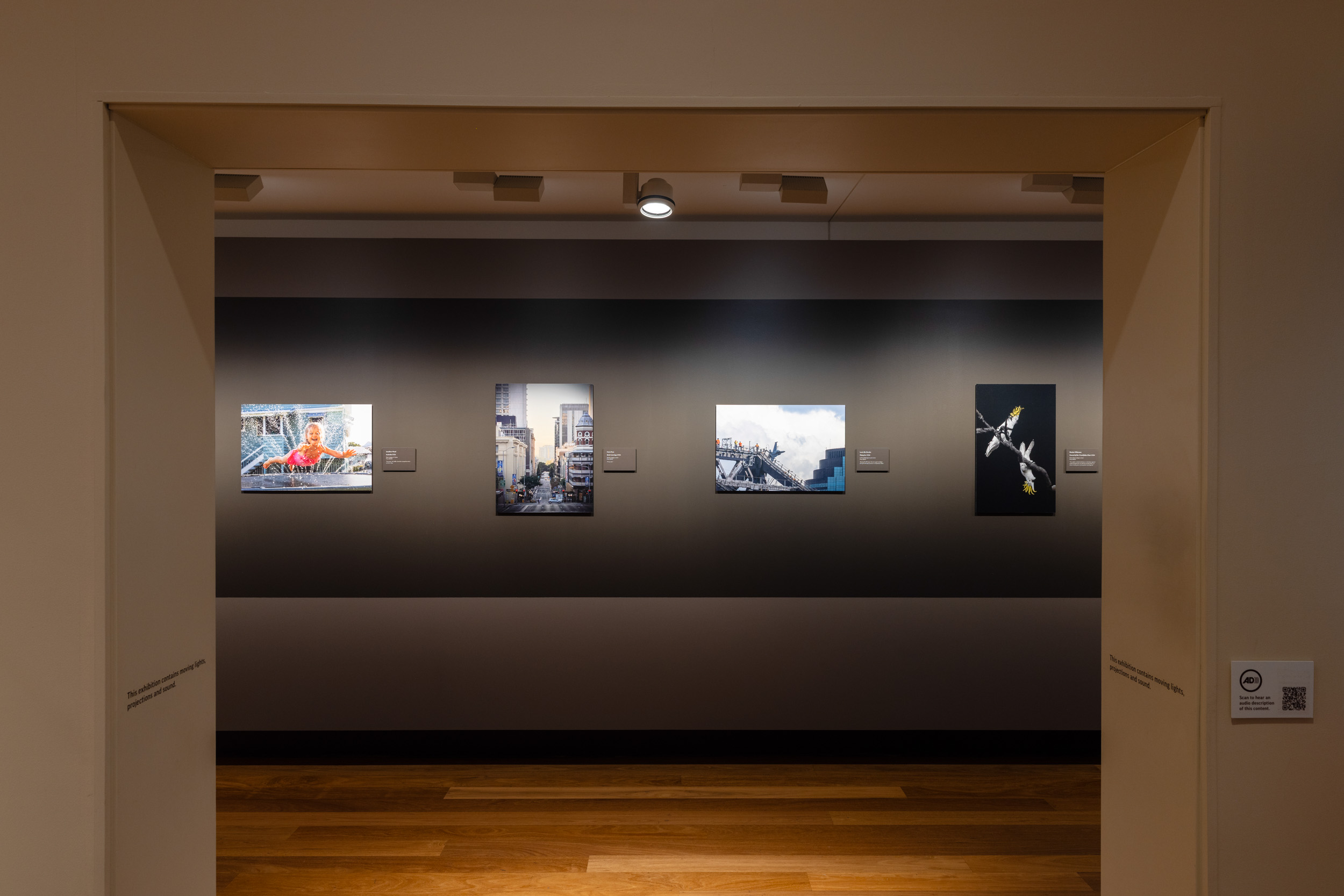 Photographic exhibition with four pictures of everyday Brisbane in view.