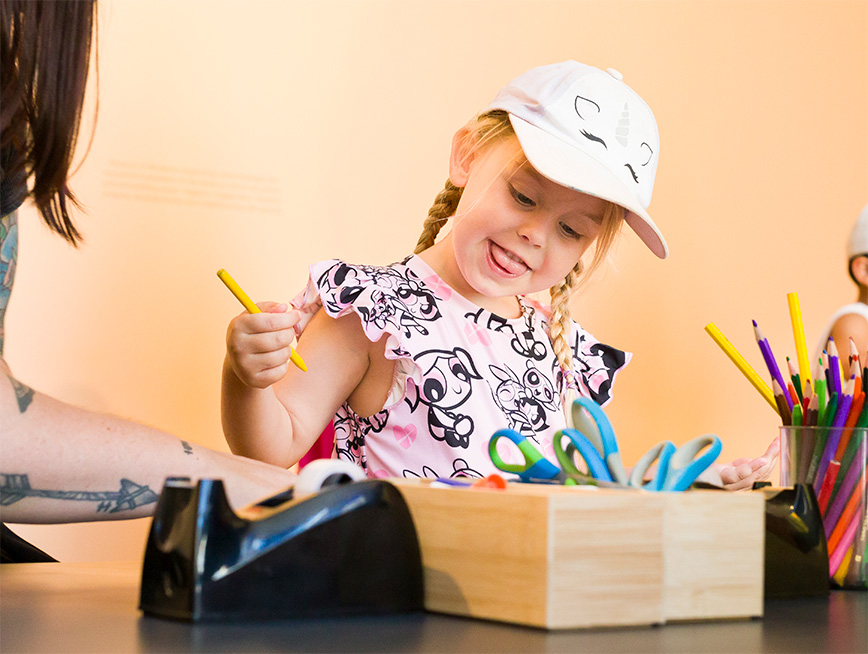 Child smiling with pencil in hand