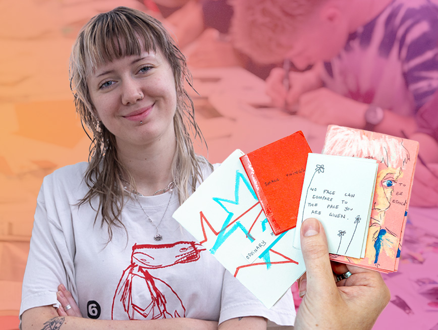 Hand holding up four home-made zines and artist smiling next to it