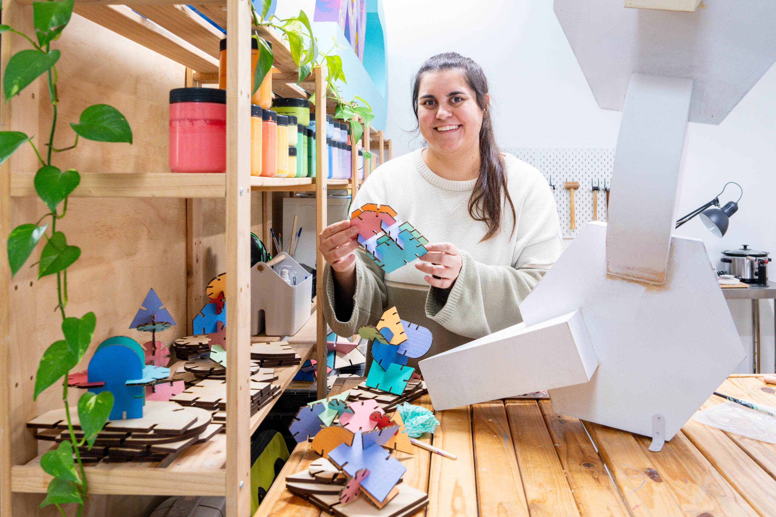 Artist surrounded by sculptures in a studio