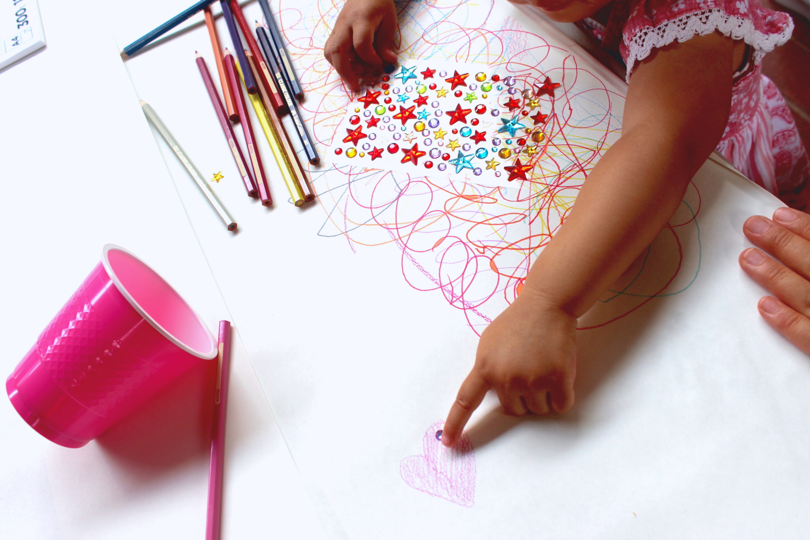Small child drawing scribbles on a piece of paper