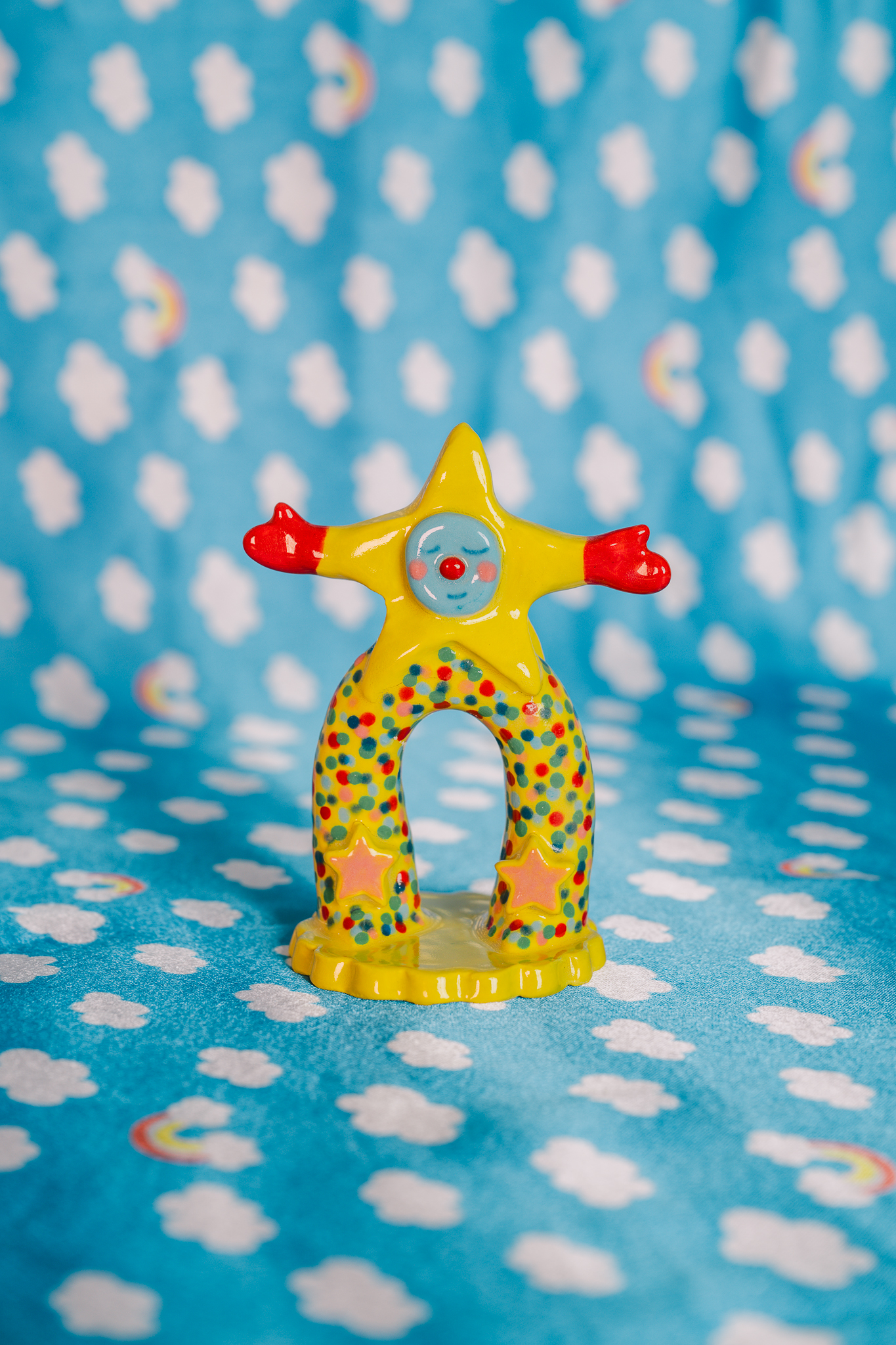 Glazed ceramic with lots of personality. Features a star with legs and arms smiling.