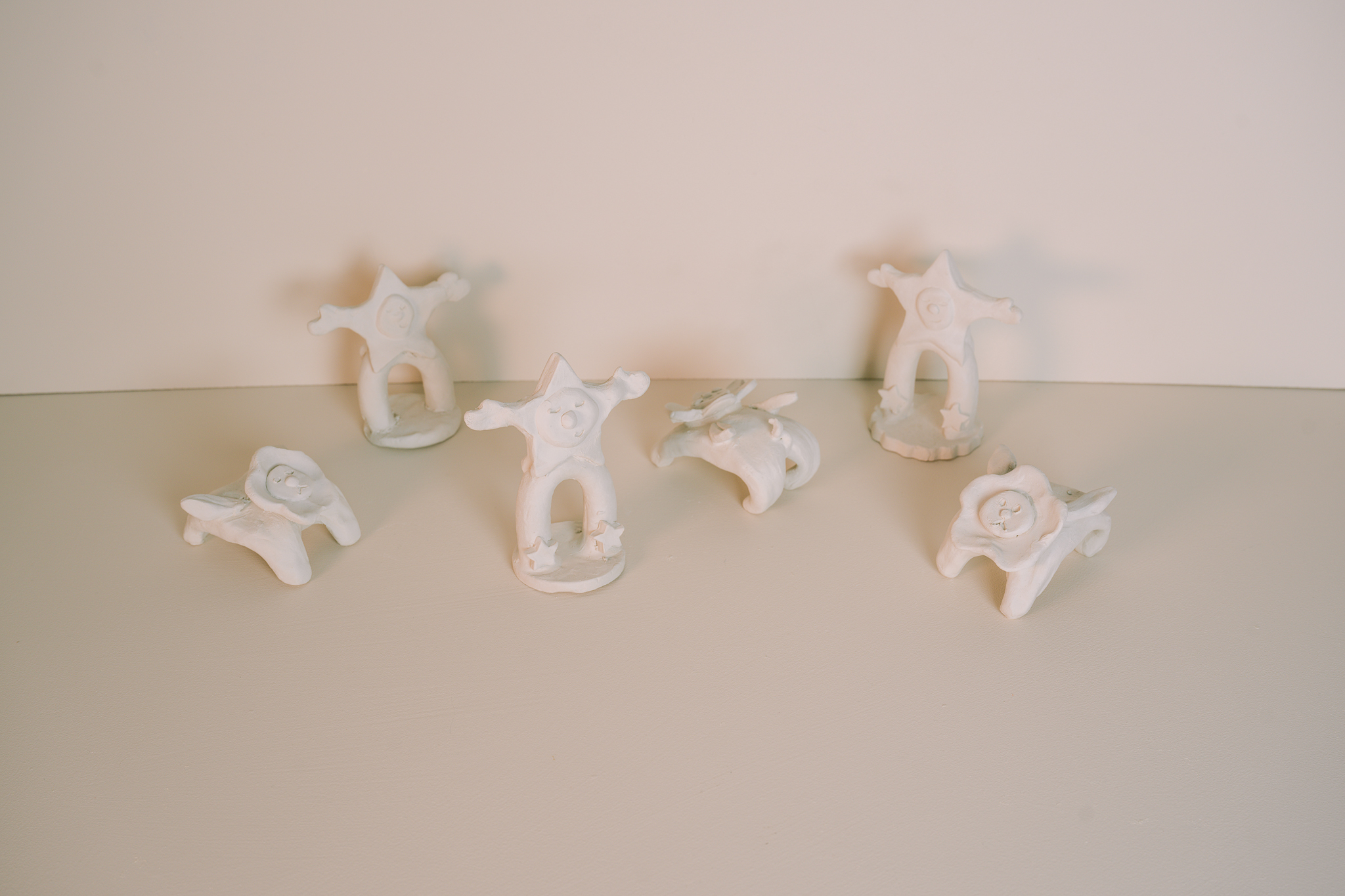 A variety of playful ceramics, shaped as little star people and flower dogs.