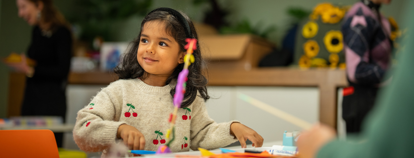 A girl making at the craft table.