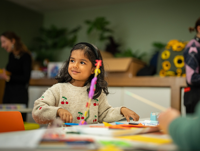 A girl making at the craft table.