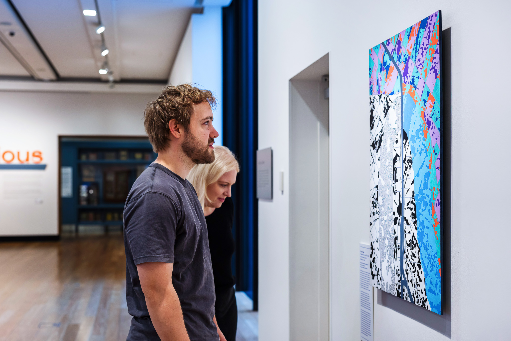 Visitors at In Residence exhibition, looking at a work by Dylan Bolger.